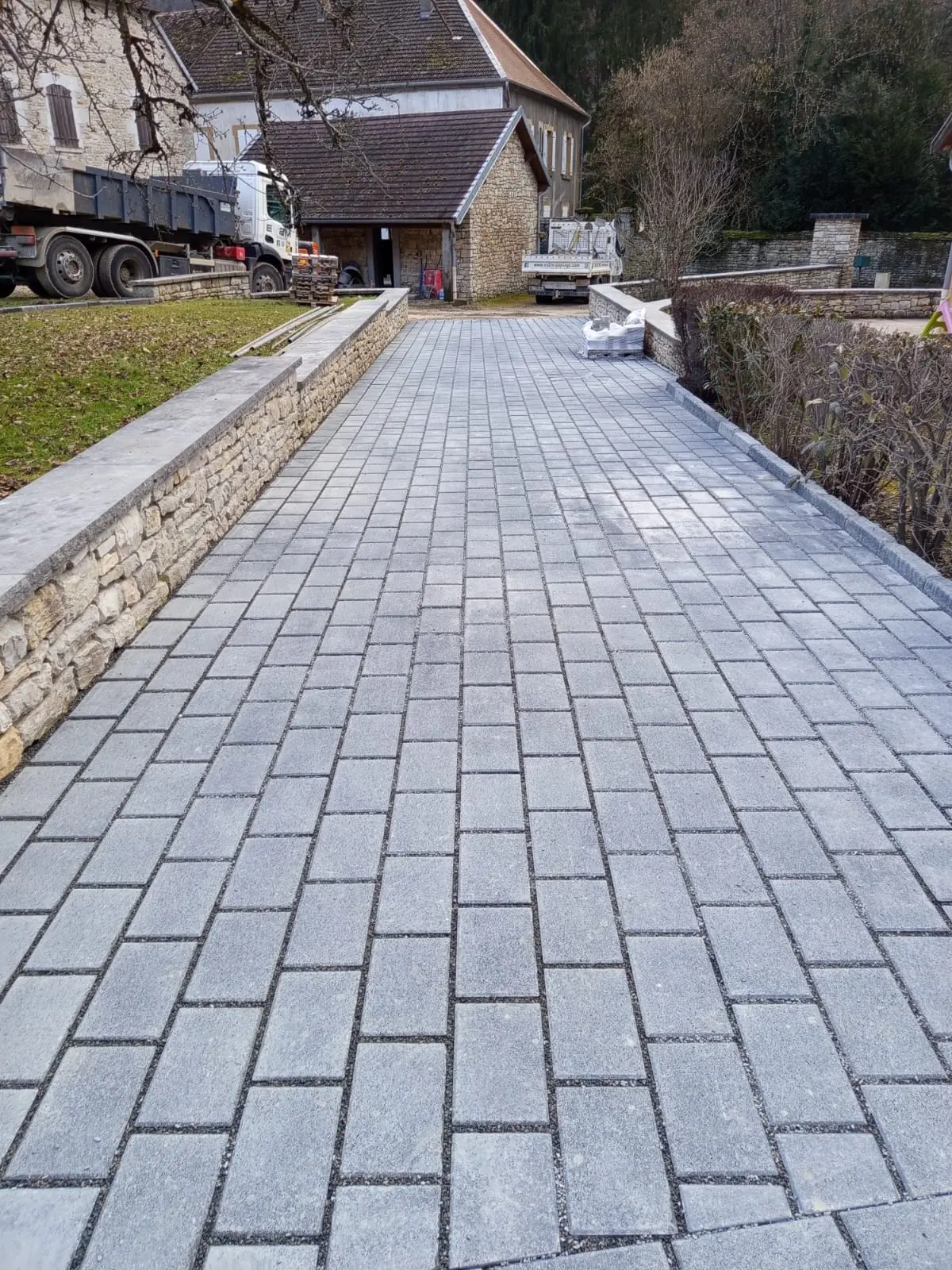 Grande allee pavee et cour amenagee par EV2M, avec muret en pierre