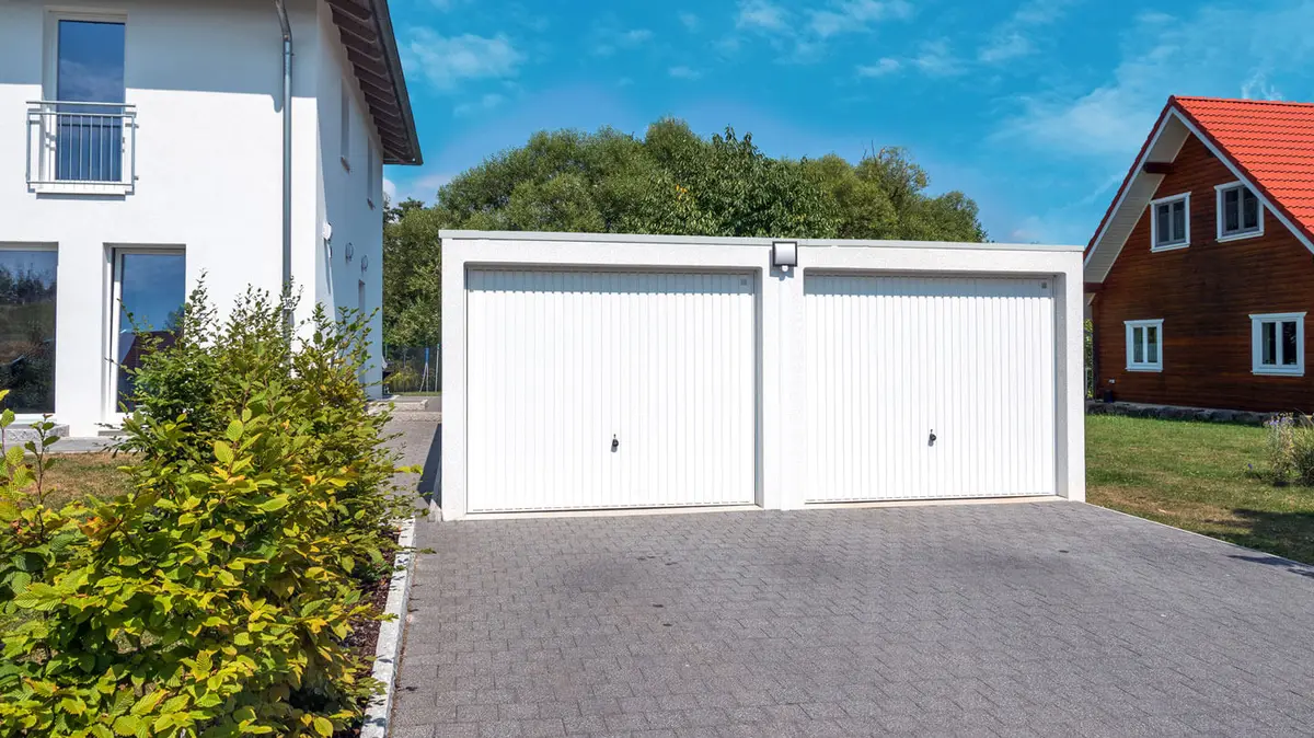 Garage beton double blanc dans un jardin