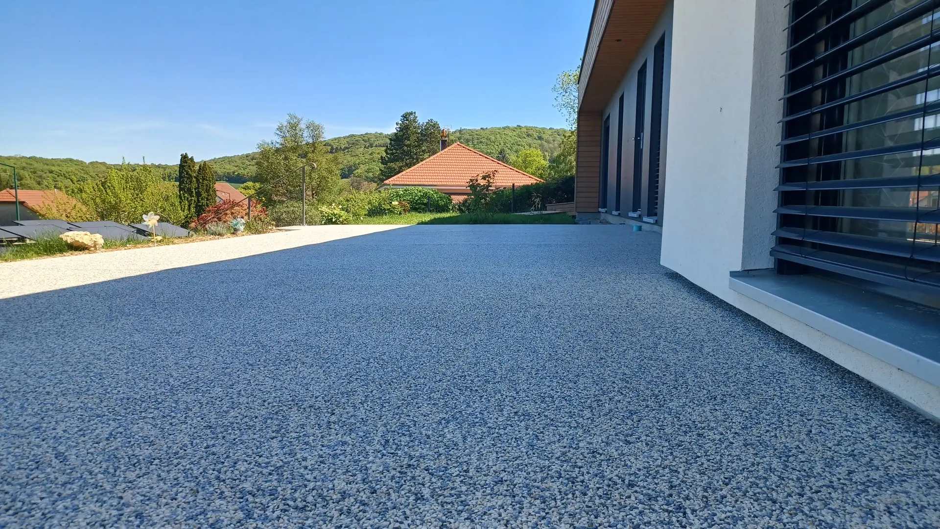 Grande terrasse en resine drainante (moquette de pierre) realisee par EV2M au soleil